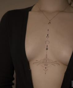 a woman's chest with an arrow tattoo on it