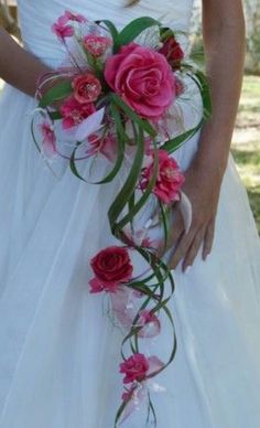 a bride holding a bouquet of pink flowers