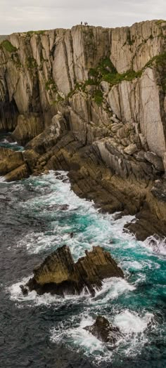 an ocean view with waves crashing on the rocks