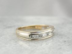 a wedding ring with three baguets on it