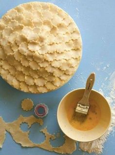 a blue table topped with lots of food and a bowl filled with batter next to a paintbrush