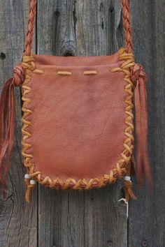 "This small leather handbag is made of soft durable leather and has a four point braided strap. The braided strap makes it so you can easily wear your bag crossbody. The color of the leather is rust with contrasting saddle lace. This handmade crossbody purse has a inside pocket and one on the back and has an antler button for a closure. Measurements are 7\" tall x 6\" wide x 1 1/2\" deep. It is decorated with glass crow beads... This item is MADE TO ORDER. Please read our policy on made to order Leather Braided Tote Bag, Everyday Braided Leather Bags, Brown Leather Braided Shoulder Bag, Brown Braided Leather Shoulder Bag, Braided Leather Shoulder Bag, Brown Braided Crossbody Bag, Woven Leather Pouch Shoulder Bag, Leather Purse Diy, Reusable Grocery Bags Pattern