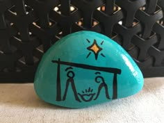 a painted rock with a nativity scene on it and a star above the top