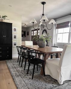 a dining room table with chairs and a rug on the floor in front of it