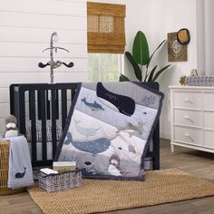 a baby crib bedding set with blue and white whale prints