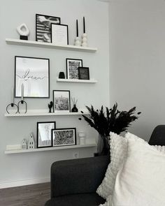 a black and white living room with pictures on the wall, pillows, and vases