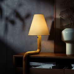 a lamp on a table next to a book shelf