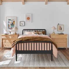 a bed room with a neatly made bed and two dressers on either side of the bed