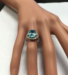 7.80 Carats Natural Very Nice Looking Blue Zircon and Diamond 14K Solid White Gold Ring Suggested Replacement Value: $6,500.00 Total Natural Oval Cut Blue Zircon Weight is: 7.00 Carats Natural Round Diamonds Weight: .80 Carats (color G-H / Clarity SI1-SI2) Ring total weight: 6.1 grams Disclaimer: all weights, measurements and colors are approximate and may vary slightly from the listed dimensions or as seen in the image. All pictures are magnified to show the smallest of details. Please, refer t Blue Topaz Ring In 14k White Gold, Blue Bridal Jewelry With Diamond Accents In Cubic Zirconia, Formal Aquamarine Diamond Ring With Brilliant Cut, Aquamarine Brilliant Cut Diamond Ring For Formal Occasions, Blue Aquamarine Diamond Ring, Formal Blue Brilliant Cut Gemstones, Dazzling Diamond Ring With Accent Stones For Formal Occasions, Blue Diamond Cluster Ring With Round Cut, Blue Brilliant Cut Gemstones For Formal Occasions