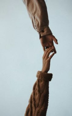 two hands reaching up to each other in the air