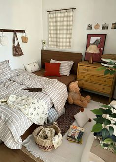 a bed room with a neatly made bed and some stuffed animals on the floor next to it