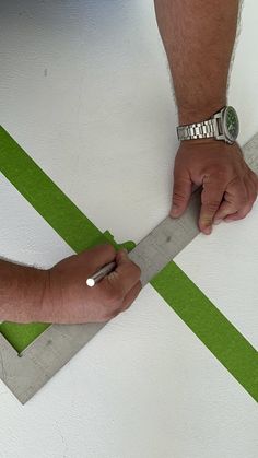 a man is cutting paper with a pair of scissors on top of the floor in front of him