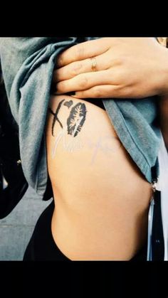 a woman's stomach with tattoos on it and her name written on the side