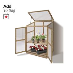 a small wooden greenhouse with plants in it