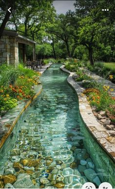 an image of a river that is in the middle of some rocks and flowers on it