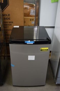 a small refrigerator in a room next to boxes