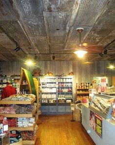 the inside of a grocery store with lots of items on shelves and wooden flooring