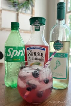 Photo of a moscato wine spritzer in a short wine glass made with Blueberry Lemonade garnished with fresh blueberries with a purple and white straw. A bottle of sprite, blueberry lemonade and moscato are behind the glass. Wine Spritzer Recipe, Peach Cobbler Pound Cake, Almond Joys, Easy Lemonade, Buttermilk Muffins, Spritzer Recipes, Wine Spritzer