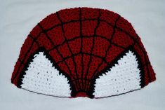 A crochet Spider-Man hat with hand sewn detailing. Will fit most adults. This hat is made to order so that I can customize the size from adults to children. See image for Measurement Guide: Measurement A: The brim of the hat, where it sits on the crown of your head, is about 23 inches, and can stretch to about 25 inches. Measurement B: From front of hat to the back (where is sits on your brow to the back of your head), is about 16 inches. Customization includes the size of the hat. Send me the measurements as shown in the image. Can be customized for adults, teenagers, and children. These items are handmade to order so I can customize each one, so please excuse the delay, each one will be shipped out 3-5 days after ordering. Handmade Fitted Beanie Cap, Handmade Fitted Yarn Hats, Handmade Fitted Crochet Hat With Curved Brim, White Handmade Crochet Hat Fitted, Fitted White Hand Knitted Crochet Hat, Handmade Fitted Brimmed Crochet Hat, Themed Red Hat One Size Fits Most, Fun Crochet Cap, One Size Fits Most, Fun Crochet Cap One Size Fits Most