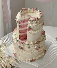 a three tiered cake with pink flowers on the top and bottom is sitting on a plate