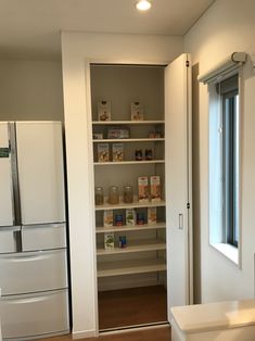 an empty kitchen with white cabinets and wood flooring is seen in this image from the doorway