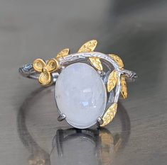 Fast free shipping Gemstone has been tested on one of the most accurate and reliable gemstone testing machines. Moonstone is genuine and is naturally mined. The flashy moonstone square earrings are brilliant. A cute moonstone sterling silver ring with 14k yellow gold overlay is perfect for the spring. It will remind you of white cherry blossoms in the spring. This moonstone ring has iridescent beautiful blue flashing hues. Rainbow Moonstone activates the Crown Chakra bringing In loving white hea Luxury Fine Jewelry Moonstone Ring For Anniversary, Luxury Untreated Moonstone Ring For Anniversary, Handmade Silver Moonstone Ring Fine Jewelry, Elegant Silver Moonstone Ring, Silver Moonstone Ring Fine Jewelry For Gift, Fine Jewelry Silver Hallmarked Moonstone Ring, Silver Moonstone Ring Fine Jewelry, Delicate Silver Moonstone Ring For Gift, Silver Oval Cabochon Moonstone Ring For Wedding