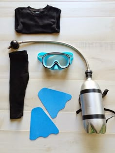 scuba gear laid out on the floor with water bottle, snorkels and other items