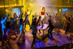 a group of people standing on top of a stage with their arms in the air