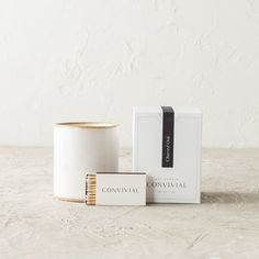 a white candle next to a boxed box