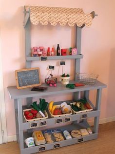 a shelf filled with fruits and vegetables next to a chalkboard on top of a wall