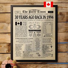 an old newspaper with the canadian flag hanging on a wooden wall next to a cake