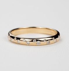 an image of a wedding ring with diamonds on the inside and outside, in yellow gold