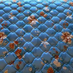 a blue quilt with flowers on it is shown in close up view from the bottom