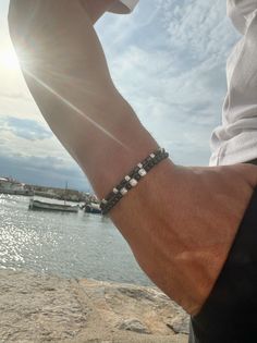 Elevate your style with our meticulously crafted pair of hematite beaded bracelets for men. Designed with a minimalistic aesthetic, the black and silver color combination exudes sophistication. The first bracelet features a central charm adorned with three tiny seashells, while the second boasts rectangular charms for a unique touch. Choose from four different dimensions for a perfect fit. Embrace this exclusive set, available only at Christina Christi Store. 👉 My Mens Bracelets Collection: htt Black Bead Bracelet Men, Cheap Beaded Bracelets For Men As Gift, Homemade Bracelets With Beads For Boys, Men’s Freshwater Black Pearl Bracelet, Mens Bracelets Aesthetic, Men Silver Accessories, Mens Bracelet Beads, Beaded Bracelet Men, Men’s Beaded Bracelet