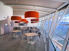 an empty classroom with many desks and chairs in front of large windows overlooking mountains