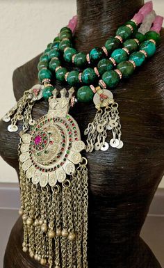 Huge 20 mm luxury turquoise round beads are each separated by pink rhinestone rondelles in this big, bold, heavy and dramatic showstopper tribal - ethnic beaded chest piece. The back of the necklace is finished with two shades of frosted pink glass beads and silver tone tribal spacers. The focal point is a big vintage Waziri Architectural Dome Pendant which measures approximately 9.5" x 4.5". The pink and green inlaid glass is intact, as are all the chain dangles. Two smaller charm dangles flank Traditional Turquoise Beaded Jewelry, Traditional Turquoise Round Beads, Bohemian Colorful Round Beads, Gems, And Cabochons, Colorful Bohemian Beads, Gems, And Cabochons, Traditional Jewelry With Gemstone Beads, Traditional Handmade Beads And Cabochons For Festivals, Handmade Traditional Beads And Cabochons For Festival, Traditional Turquoise Round Beads Jewelry, Traditional Turquoise Round Bead Jewelry