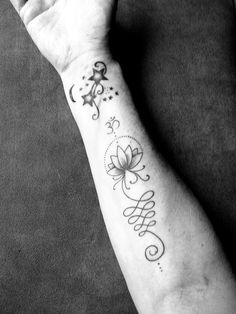 a black and white photo of a person's arm with a tattoo on it