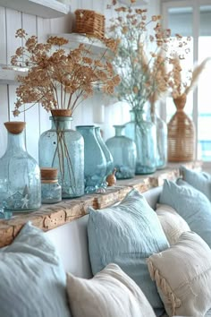 blue glass vases are lined up on a shelf in a room with white walls