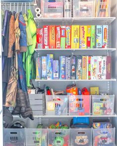 an organized closet with plastic bins and clear shelves filled with toys, books, and other items