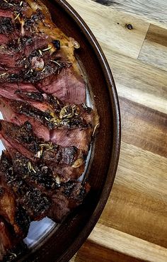 a plate full of meat sitting on top of a wooden table