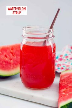 watermelon syrup in a mason jar next to slices of watermelon