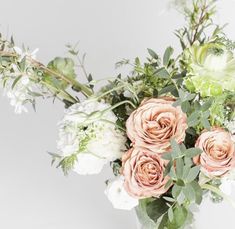 a vase filled with lots of flowers on top of a table