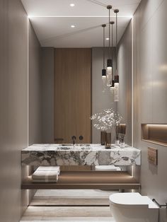 an elegant bathroom with marble counter tops and gold fixtures