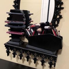 a mirror and some makeup brushes on a shelf