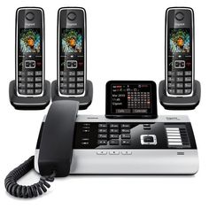 three phones are sitting on top of each other and one is connected to a cordless phone