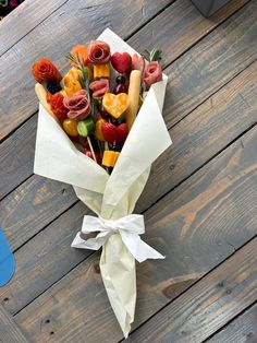 a bouquet of fruit is wrapped in white paper