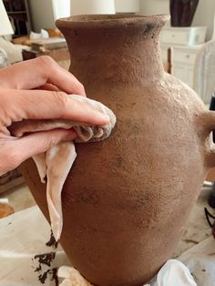 a person is working on a clay vase