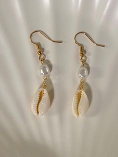 - Gold plated ✨ - Lead and nickel free 🤍 - Real cowrie seashell 🐚 - Each seashell is unique and straight from the ocean/beach 🏝️ - Please note that sometimes seashells have impurities -- they are imperfectly perfect 💖 Cheap Beige Earrings For Beach, Cheap Shell Drop Earrings, Diy Dangling Earrings, Shell-shaped Beach Jewelry With Ear Wire, Shell-shaped Ear Wire Jewelry For Beach, Ocean-inspired Shell Drop Earrings For Summer, Beach Shell Jewelry With Ear Wire, Dangle Cowrie Shell Earrings For Beach, White Shell-shaped Cowrie Shell Earrings