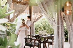 a bride and groom standing in front of a gazebo