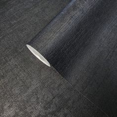 a knife laying on top of a black piece of cloth next to a white object